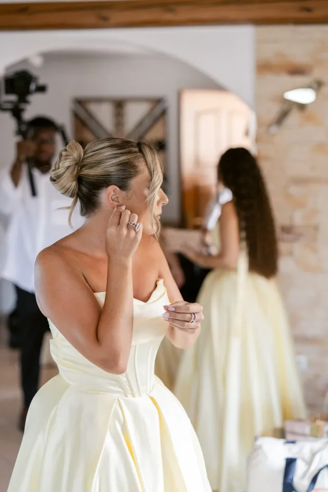 Une demoiselle d'honneur met sa boucle d'oreille pendant les préparatifs