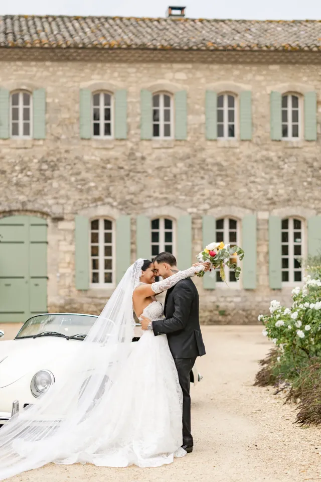 Les mariés devant la façade du couvent et le cabriolet blanc