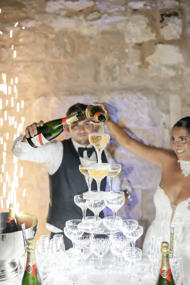 Les mariés versent le champagne sur la pyramide de coupes