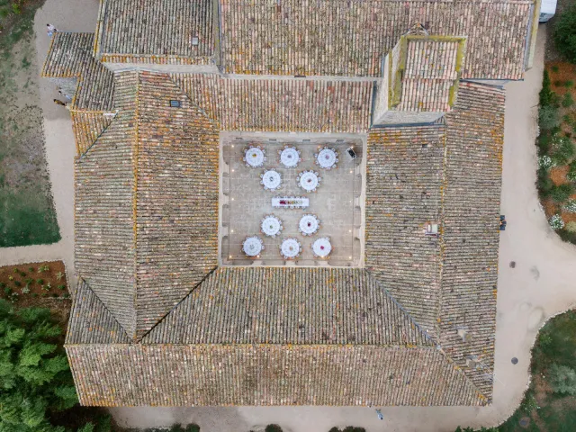 Vue du dessus de la cour du cloître, dix tables rondes dressées pour le dîner