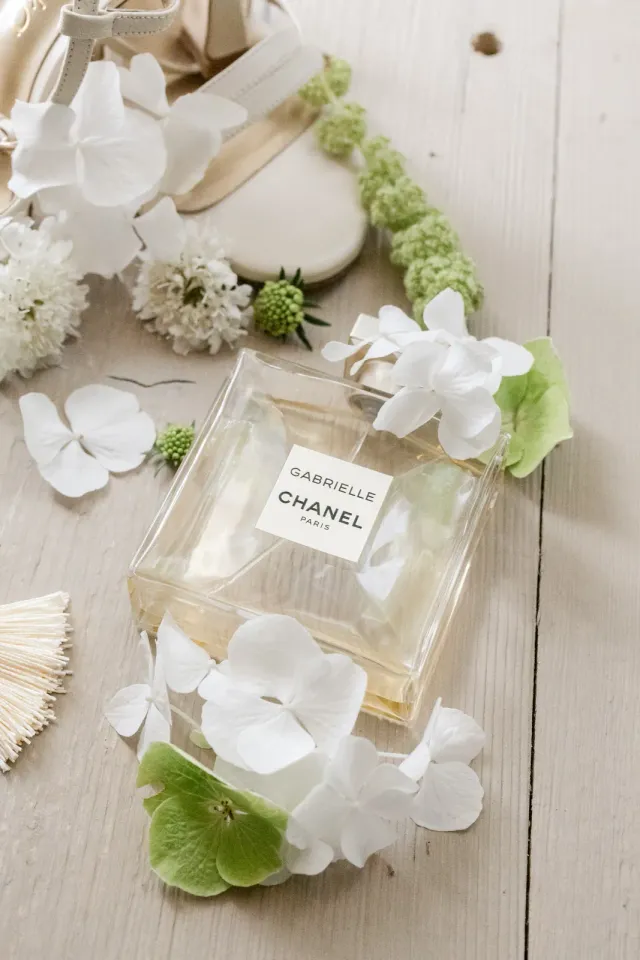 Parfum Chanel Gabrielle entouré de fleurs blanches