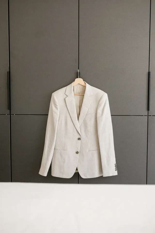 Veste de costume en lin clair Beau Costumes suspendue