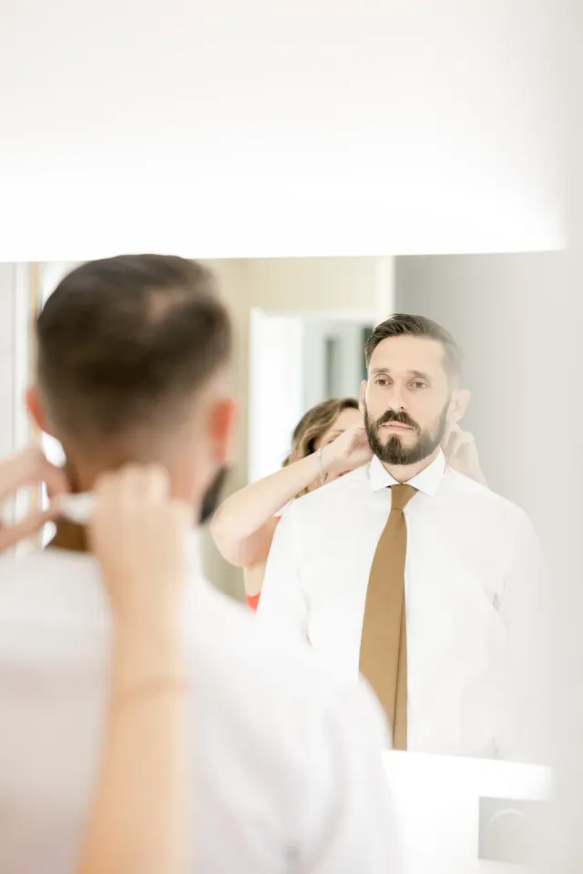 Le marié se prépare devant le miroir