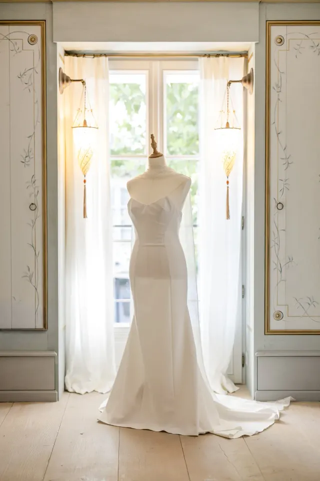 Robe de mariée Rime Arodaky suspendue devant la fenêtre