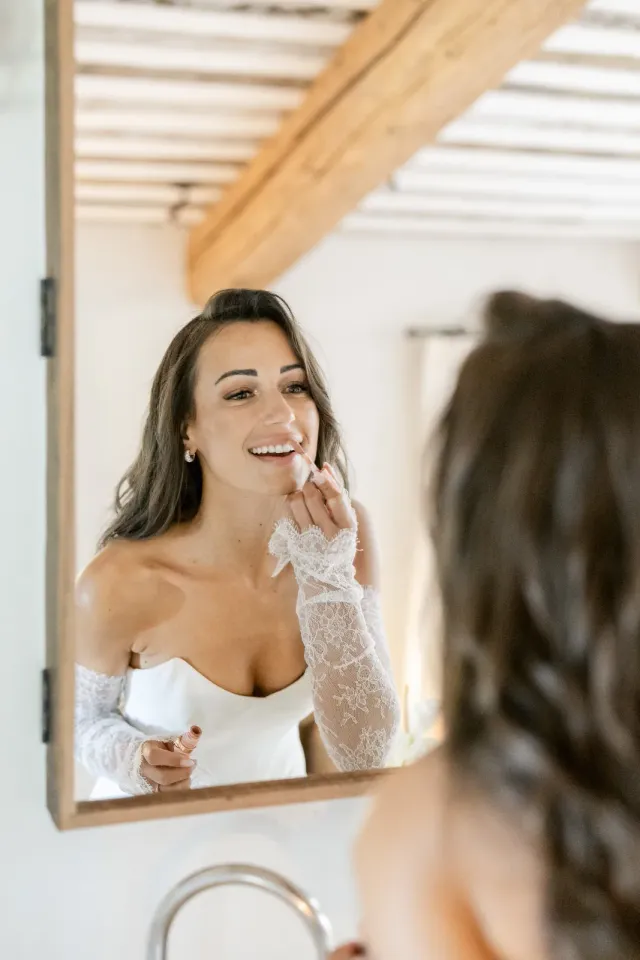 Reflet de la mariée dans le miroir, rire pendant les préparatifs