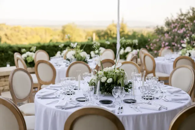 Tables rondes dressées sur la terrasse face aux vignes de Vacqueyras