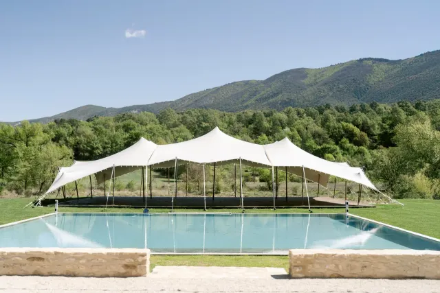 Chapiteau blanc dressé au bord de la piscine face aux collines du Luberon