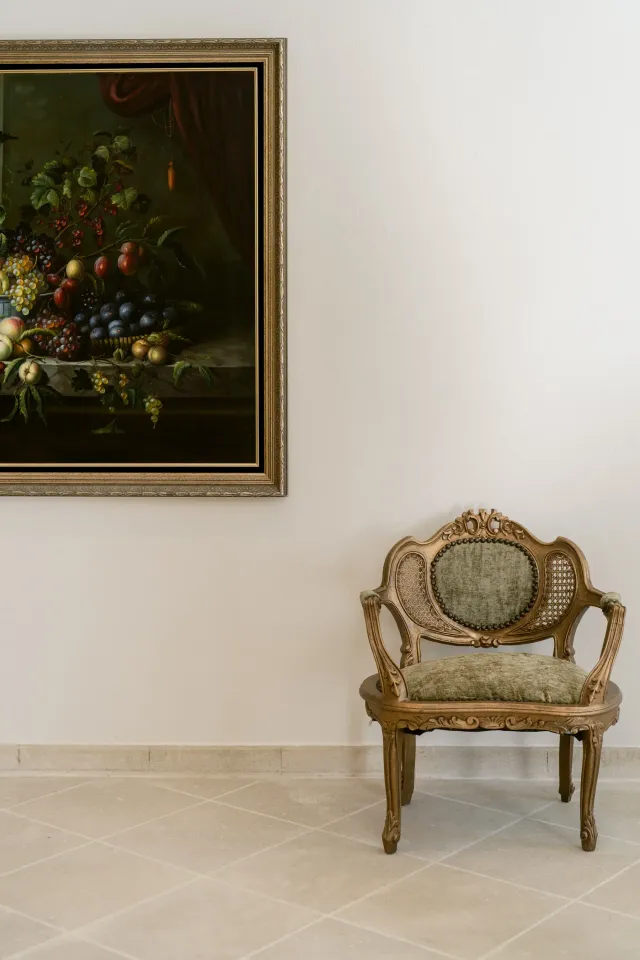 Fauteuil ancien doré devant une nature morte, intérieur du château