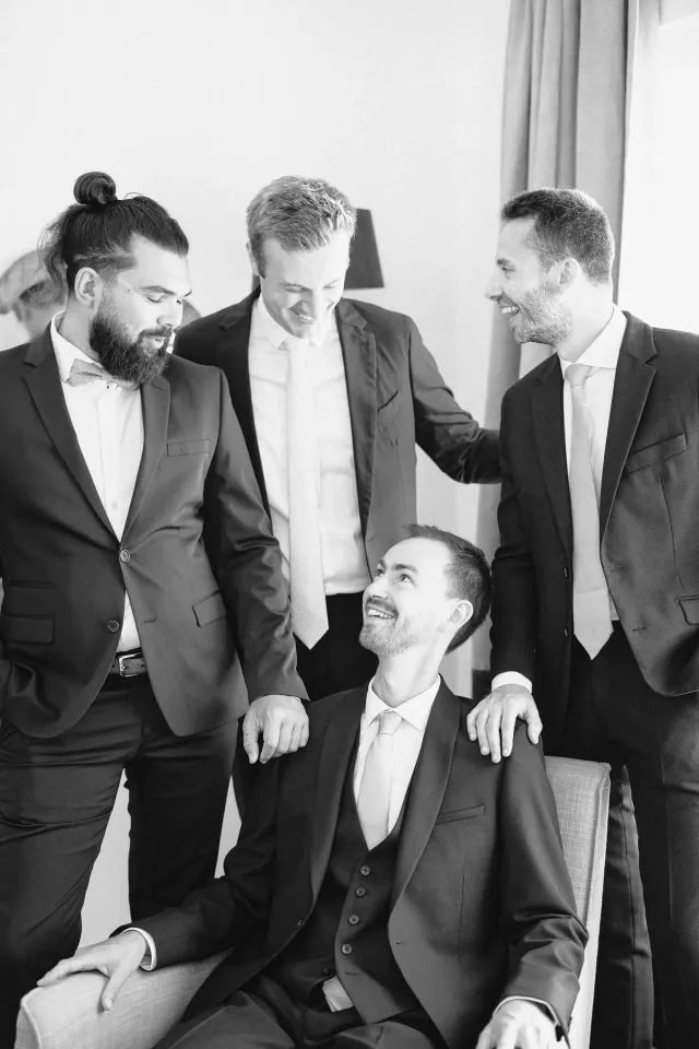 The groom and his groomsmen sharing a laugh, black and white