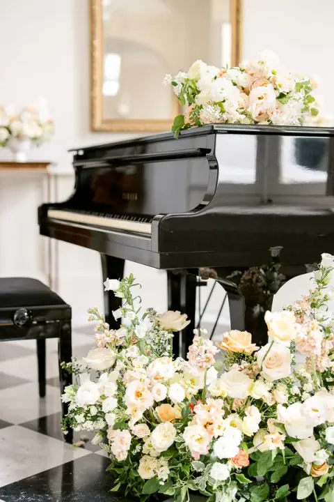 Grand piano and floral arrangements in a drawing room