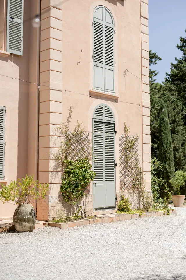 Ochre façade and sage green shutters of Château de Vaucouleurs