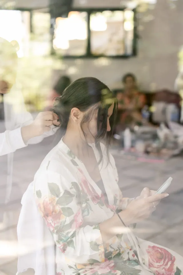 The bride getting ready in a floral robe