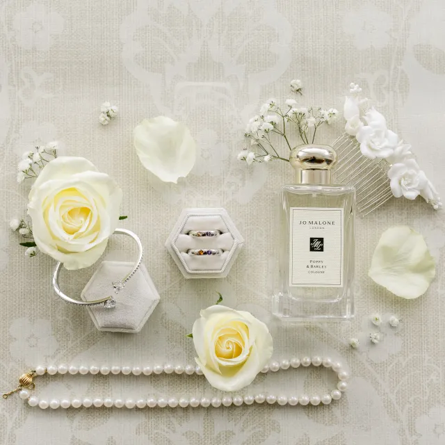 Bridal details: perfume, earrings and white roses