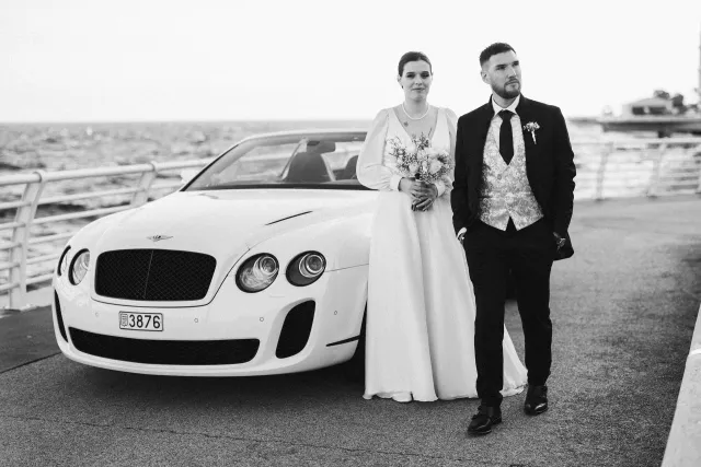 The couple in front of a white Bentley, black and white photograph