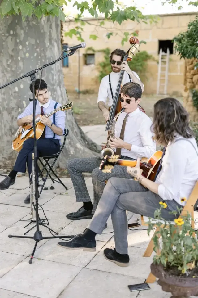 Gypsy jazz trio playing under a plane tree during the drinks reception of a wedding in Provence