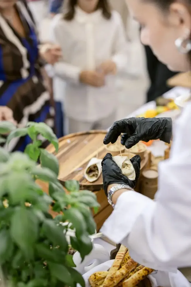 Chef serving bites by hand among basil plants, live cooking at an intimate wedding