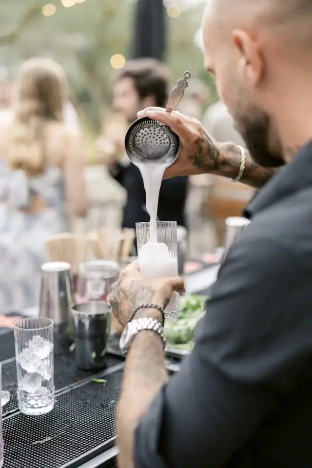 Mixologist shaking a signature cocktail during the drinks reception of a wedding in Provence