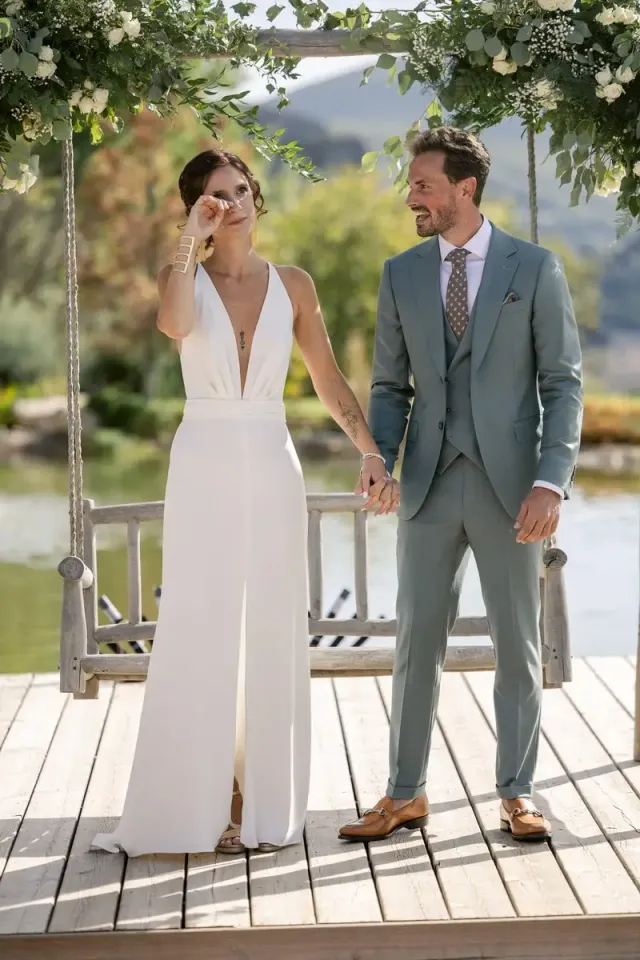 Quiet wedding in Provence, bride in a jumpsuit and groom in a blue grey suit on a wooden terrace