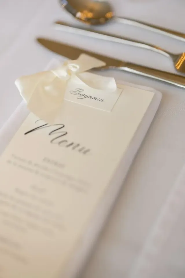 Calligraphed wedding menu on a plate, understated and elegant table detail